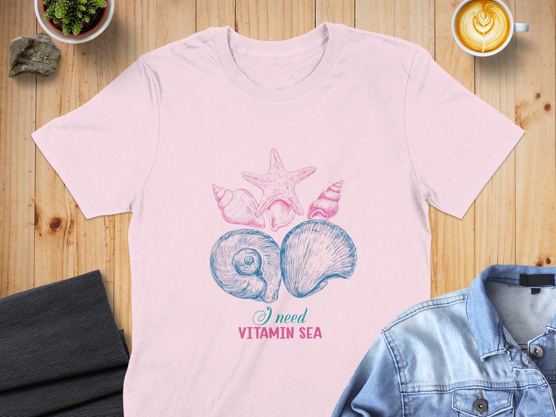 Pink t-shirt with seashell and starfish graphic and "I need vitamin sea" text.